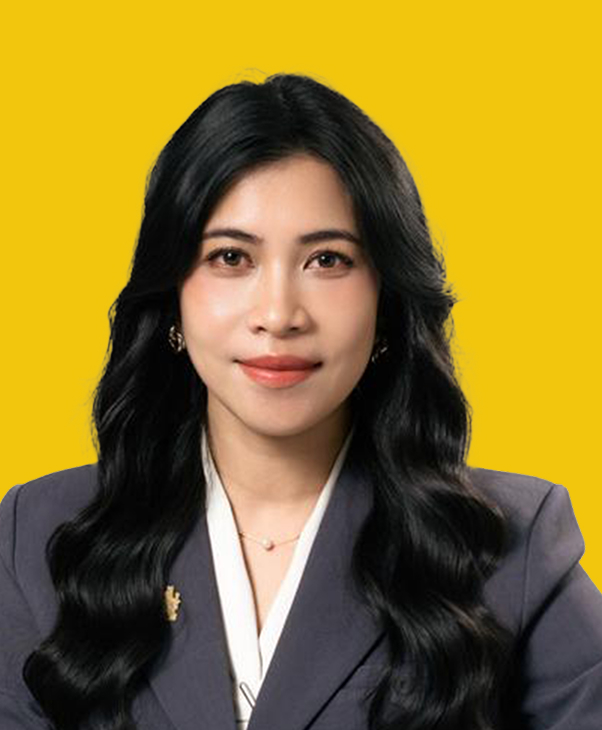 Woman in gray blazer on yellow background, looking confident.