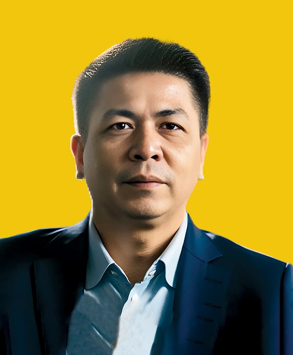 Man in blue suit on yellow background, confident.